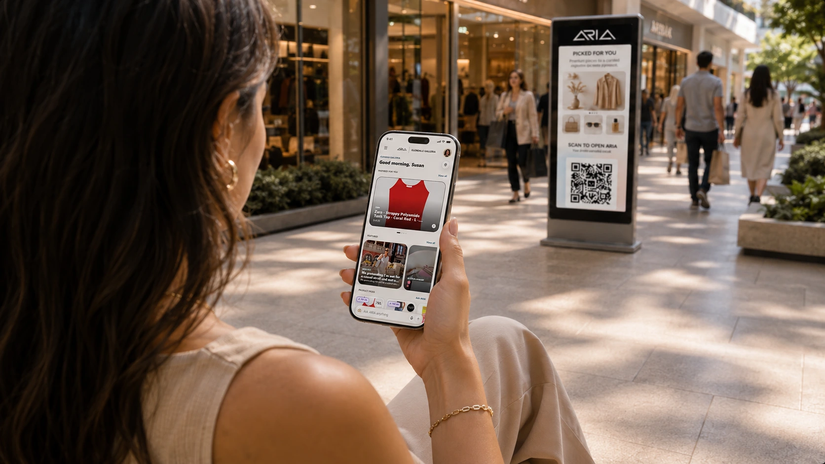 A shopper using ARIA on her phone beside a digital kiosk